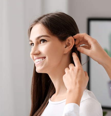 Image of young woman being fitter for a Hearing Aid - Orange Tx - Hearing Resolutions Center